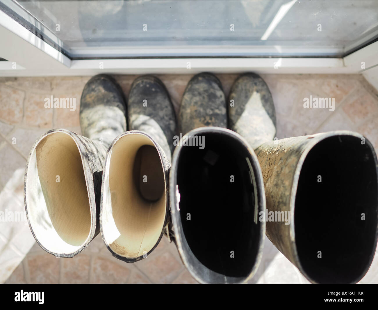 Bottes welly boueux par fenêtre véranda Banque D'Images