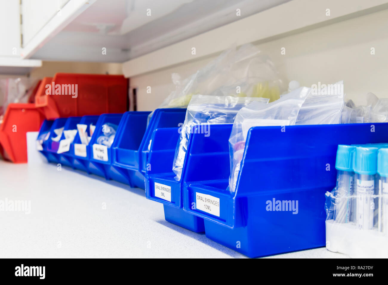Baignoires en plastique contenant de l'équipement médical, y compris les aiguilles papillon, tube vacutainer, torches etc pour prendre des échantillons de sang dans une salle de traitement de l'hôpital Banque D'Images