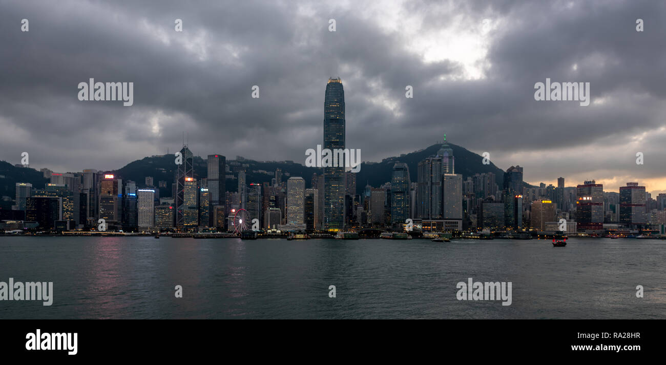 Les tours brillantes de l'île de Hong Kong dominent l'horizon alors que le soleil commence à se coucher sur l'Île Verte à l'ouest. Banque D'Images