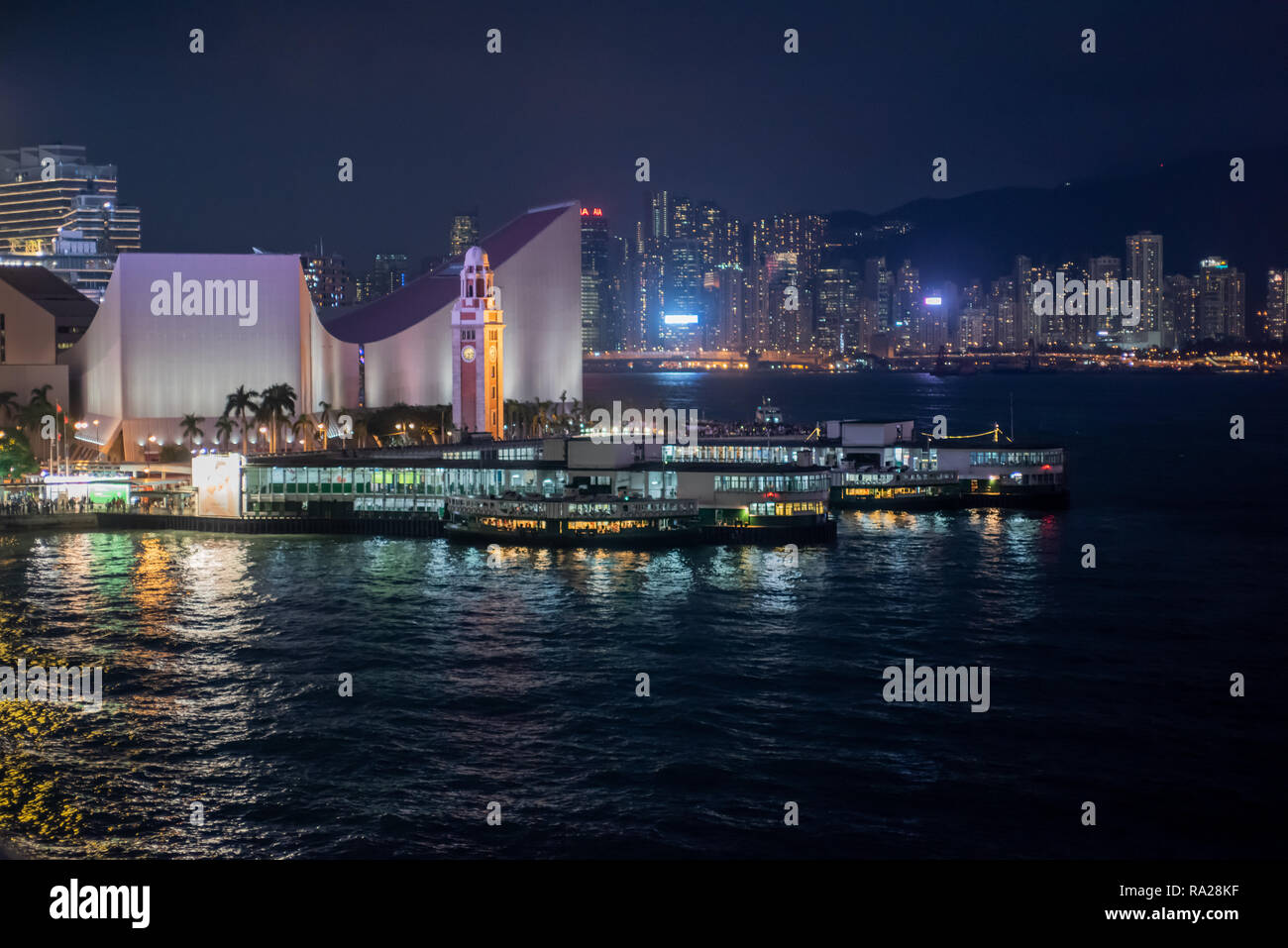Le Tsim Sha Tsui Star Ferry piers de nuit avec vue sur la Tour de l'horloge et le Centre Culturel, et l'ensemble de Causeway Bay, sur l'île de Hong Kong Banque D'Images