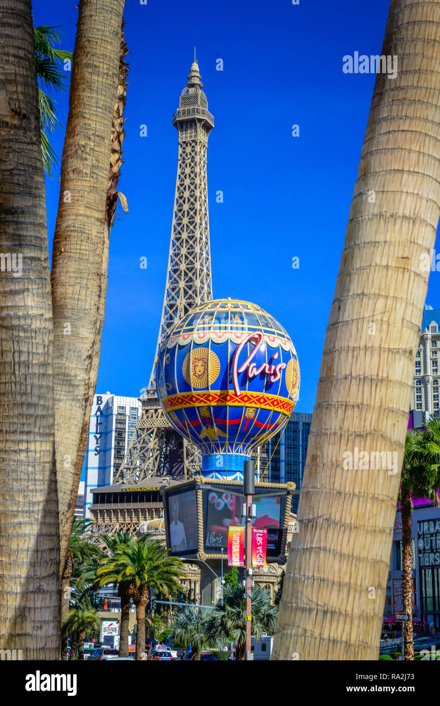 Un coup d'œil à travers les troncs de palmiers sur le Strip de Las Vegas vers le Paris Las Vegas Hotel and Casino, distincte avec son faux Tour Eiffel, NV Banque D'Images