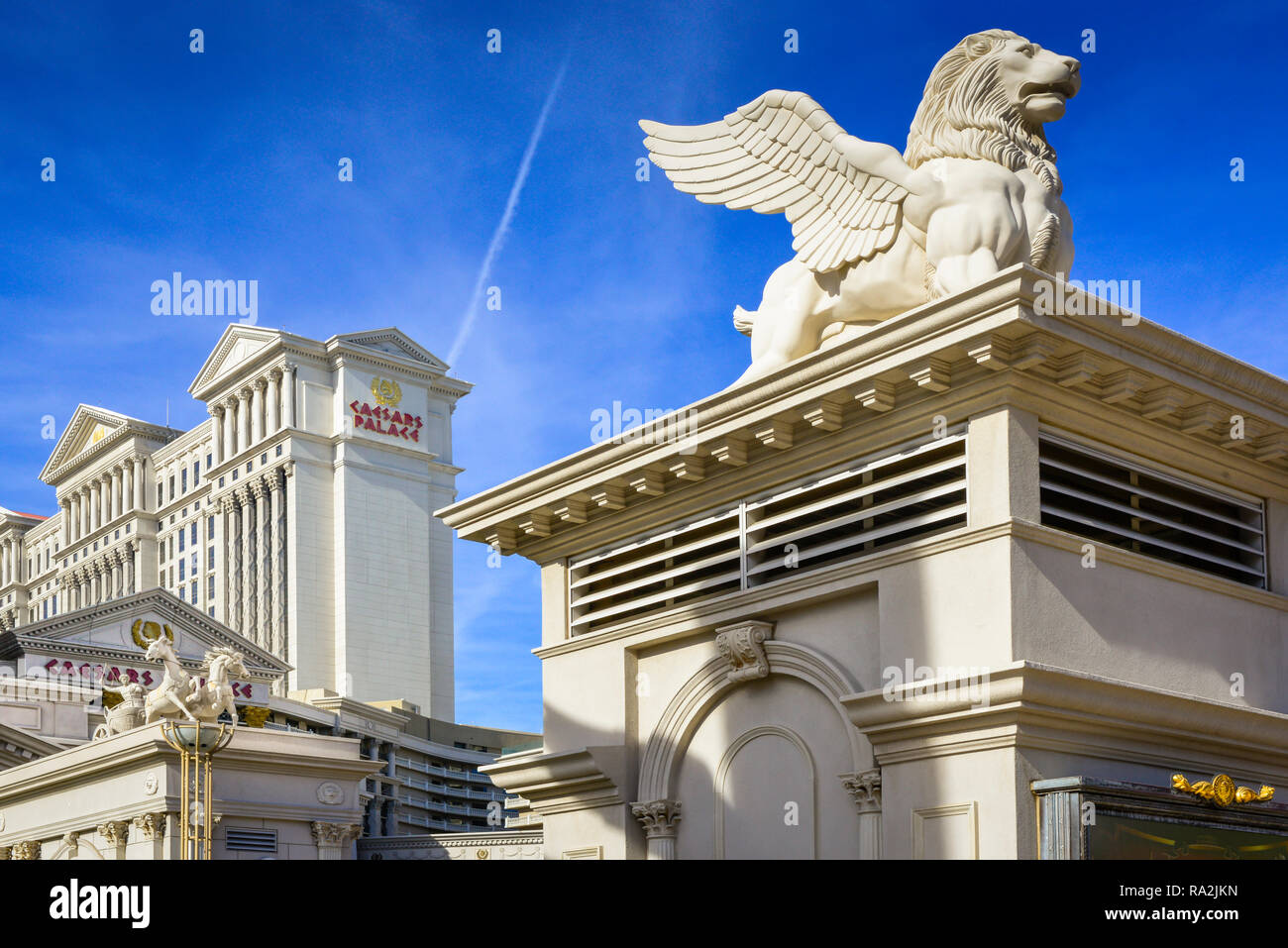 Lion ailé et chairot statuaire de course à l'entrée de l'hôtel et casino à thème Romain, Caesars Palace à Las Vegas, NV contre le ciel bleu Banque D'Images