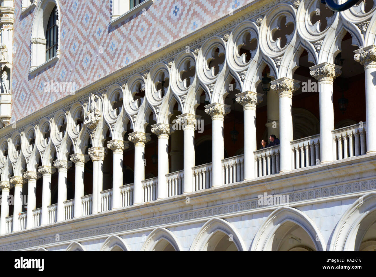 Les gens peuvent être vus peering dehors entre les colonnes et au-dessus de la balastraude de la réplique du Palazzo Ducale au Veniceian, Las Vegas NV Banque D'Images