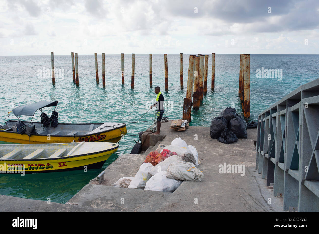 Dans les coulisses d'une destination balnéaire populaire : local man working on enlève des sacs poubelle. Johnny Cay, l'île de San Andrés, Colombie. Oct 2018 Banque D'Images