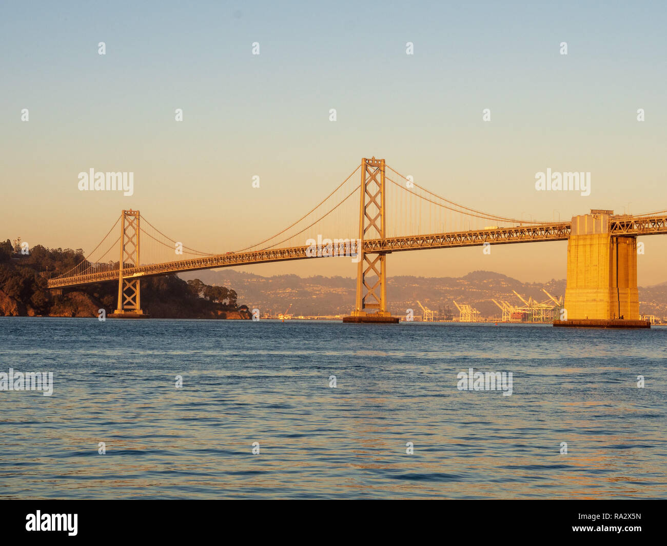 Le Pont de la baie avec le port d'Oakland et de l'île au trésor avec coucher de soleil Banque D'Images
