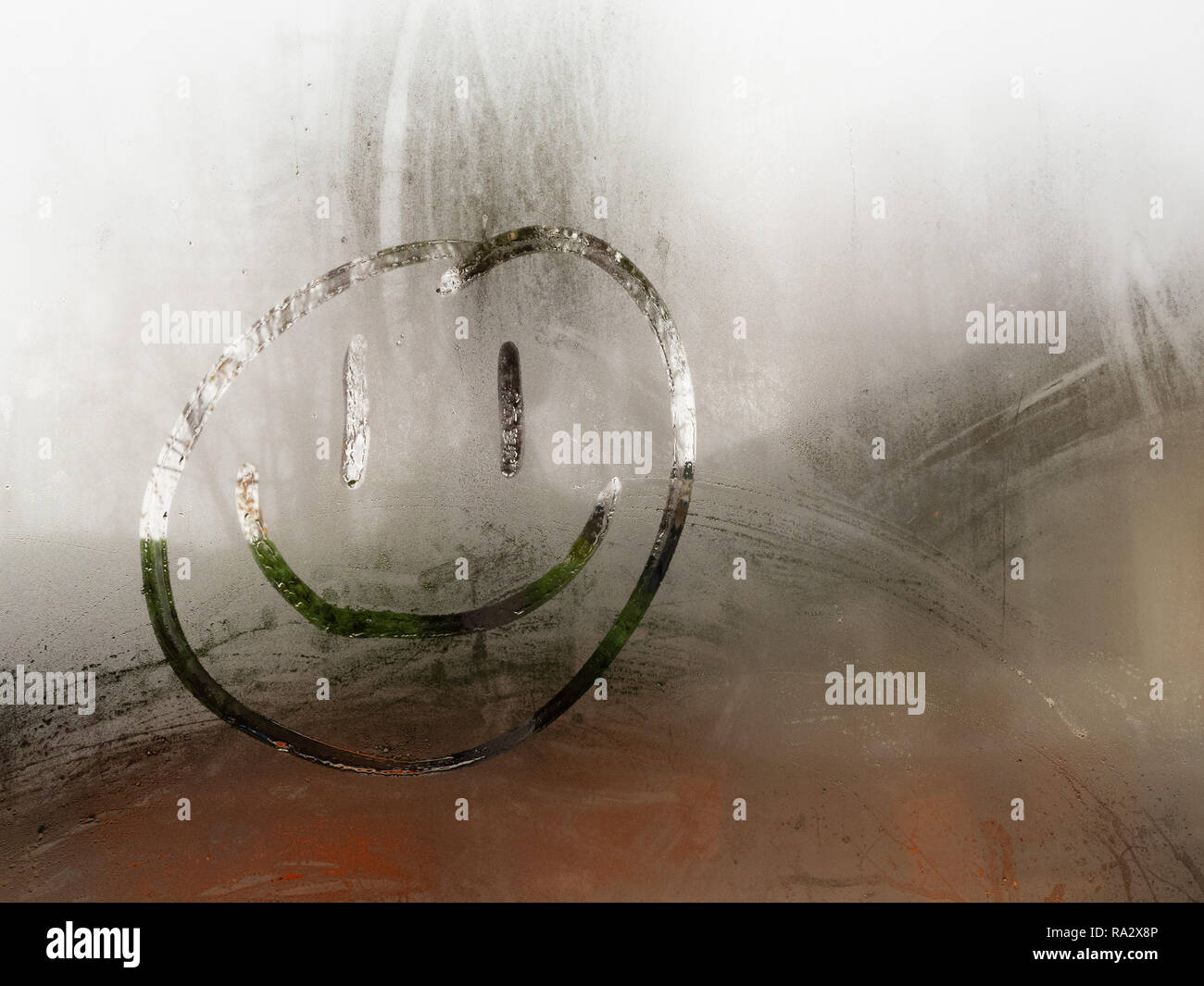 Cartoon happy smiley dessiné sur une fenêtre couverte de condensation pendant le jour Banque D'Images