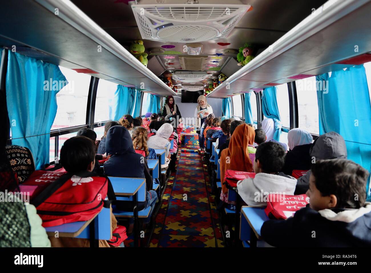 Beijing, l'Iraq. Dec 27, 2018. Les enfants fréquentent une classe dans un  bus, un 'mobile School', à Bagdad, l'Iraq, le 27 décembre 2018. Dans un  bidonville oublié dans le sud-est de Bagdad,