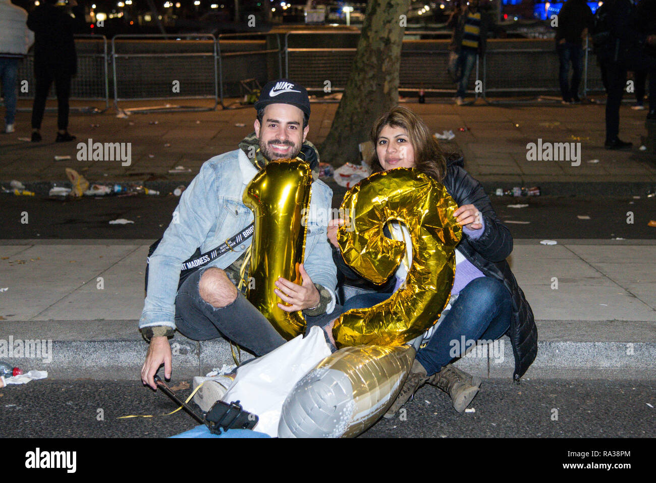 Londres, Royaume-Uni. 1er janvier 2019. Un couple tenir des ballons le numérotage des année. Londres a accueilli en 2019 avec un feu d'artifice à partir de la Coca Cola London Eye. Credit : claire doherty/Alamy Live News Banque D'Images