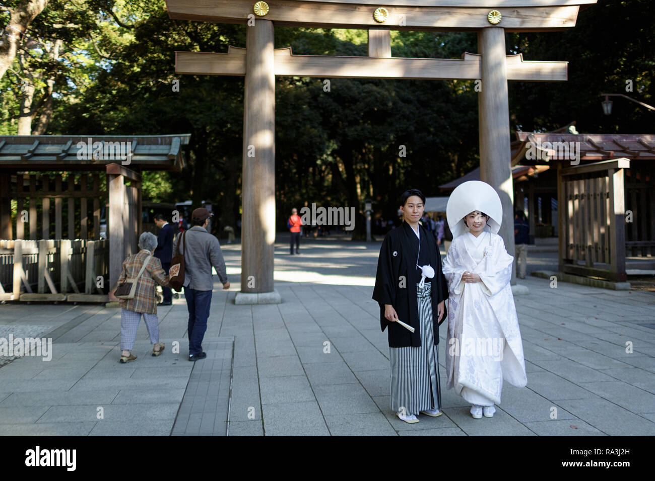 Mariée Shinto portant l'watabōshi capot blanc traditionnel posant avec le marié dans le Sanctuaire Shinto de Meiji Jingu Banque D'Images
