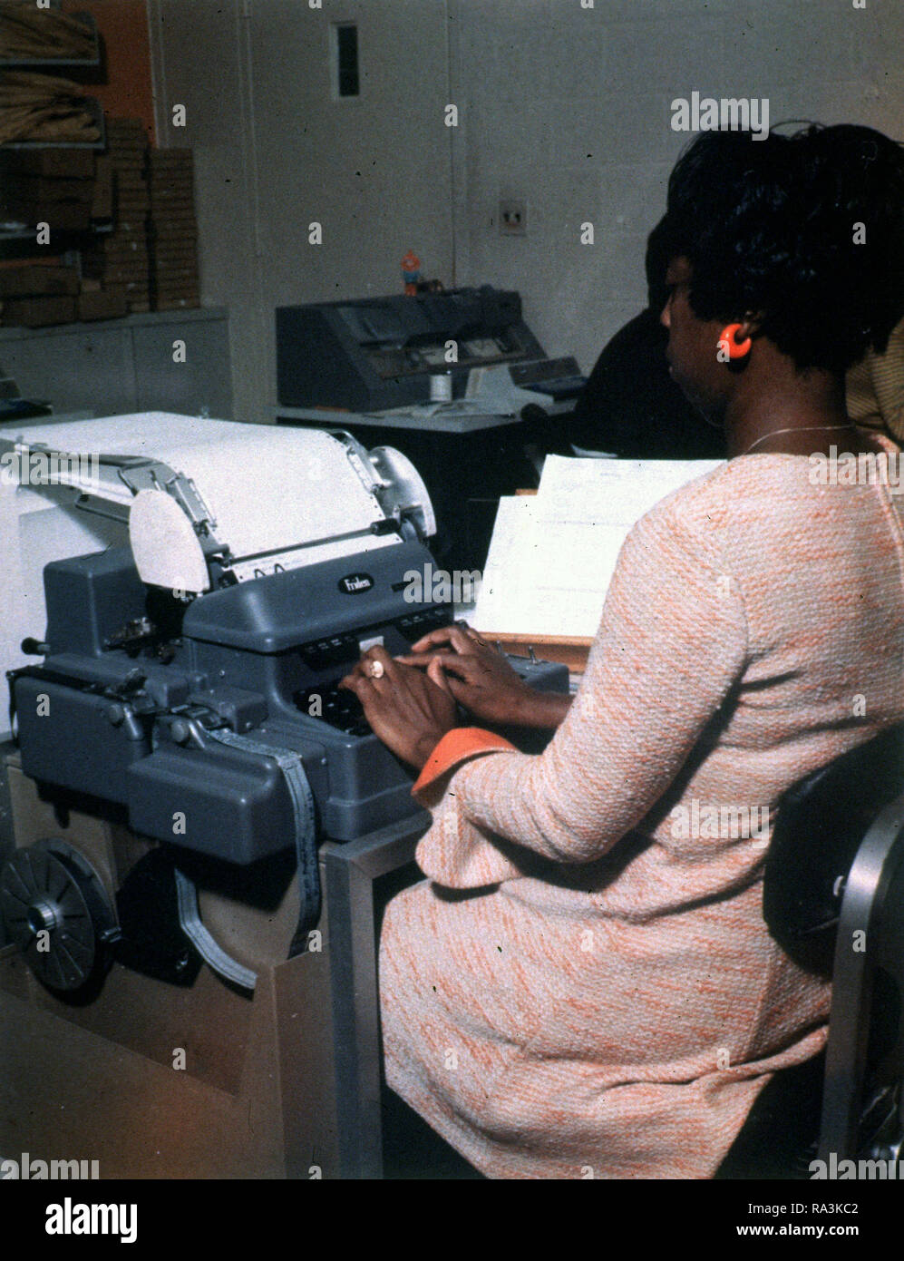 À l'aide d'une femme afro-américaine Friden Flexowriter ca. Années 1960 Banque D'Images