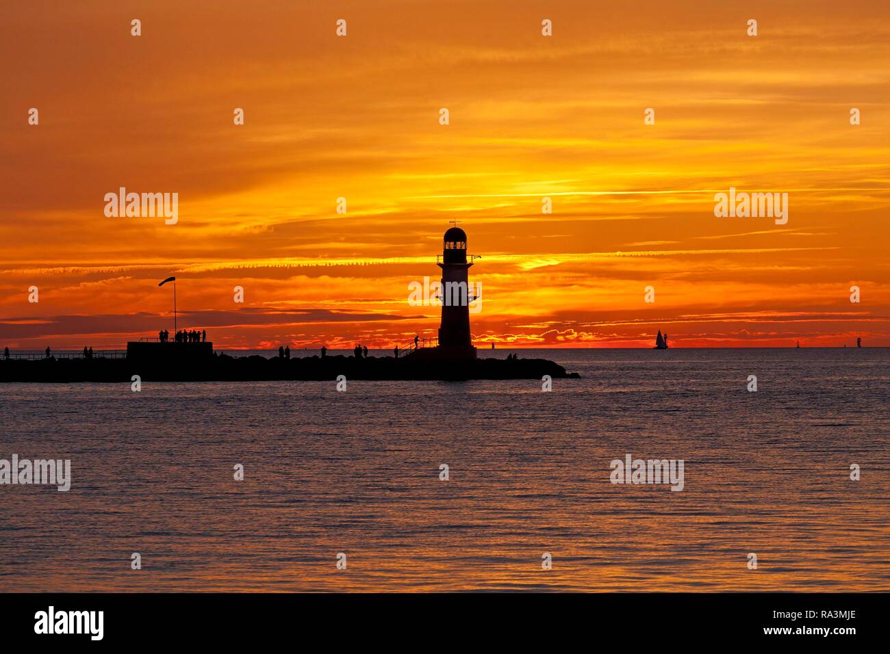 Coucher du soleil à rempart, entrée du port avec phare de Warnemunde,, Rostock, Mecklembourg-Poméranie-Occidentale, Allemagne Banque D'Images