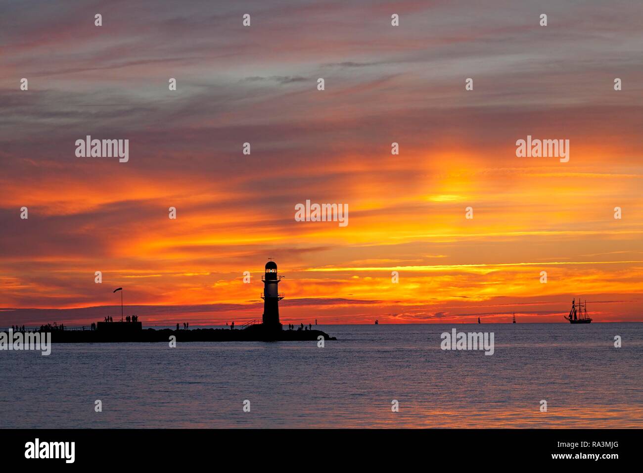 Coucher du soleil à rempart, entrée du port avec phare de Warnemunde,, Rostock, Mecklembourg-Poméranie-Occidentale, Allemagne Banque D'Images Coucher du soleil à rempart, entrée du port avec phare de Warnemunde,, Rostock, Mecklembourg-Poméranie-Occidentale, Allemagne Banque D'Images