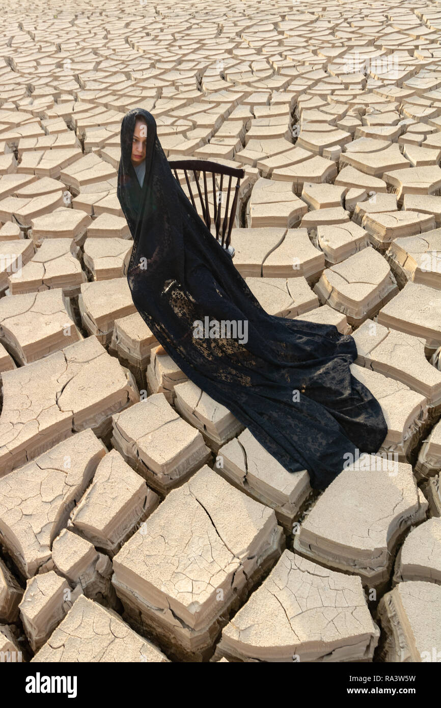 Un modèle femme islamique iranien portant le voile islamique ou hijab-sur la terre sèche Banque D'Images
