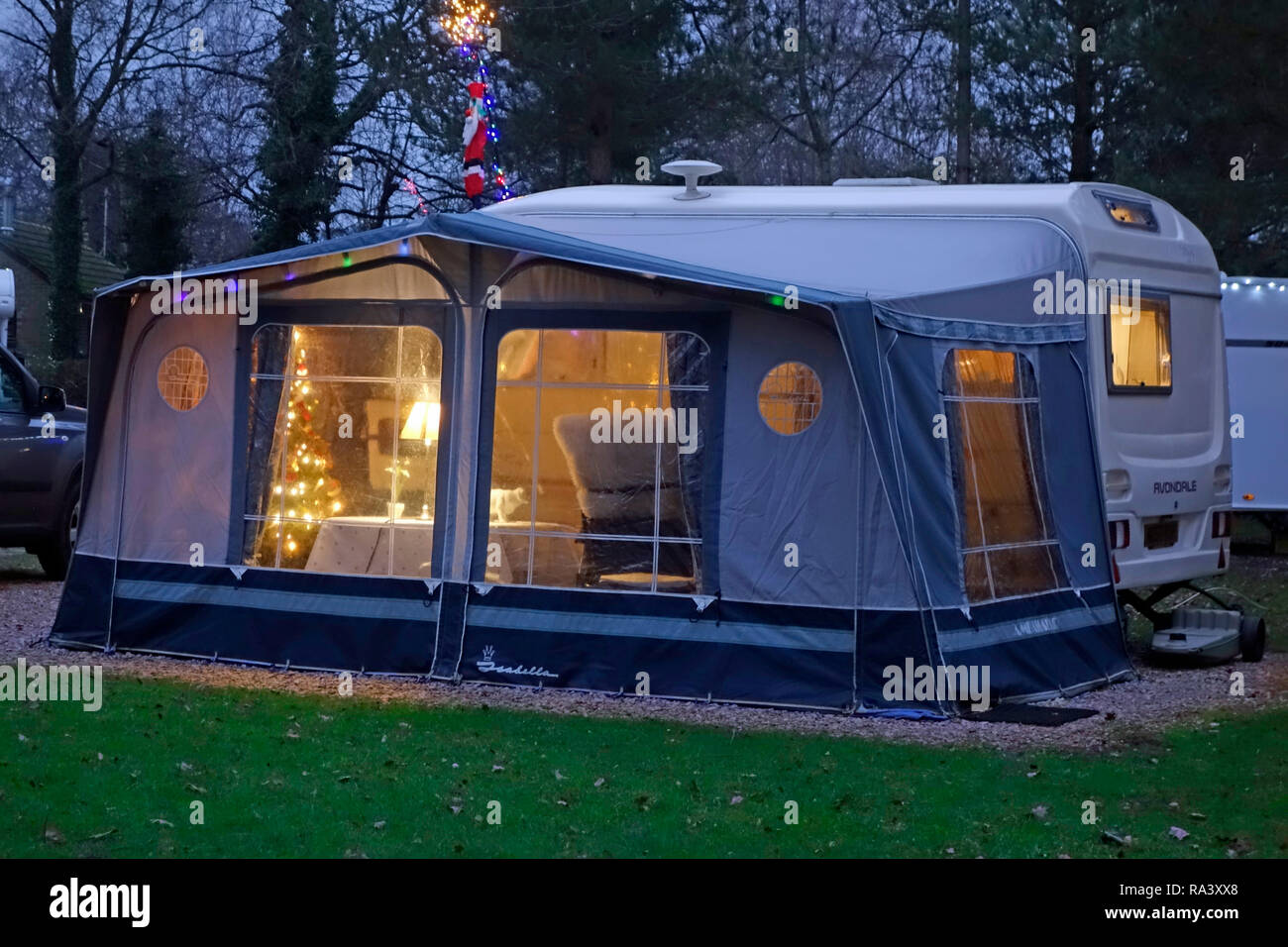 Auvent caravane éclairé avec des lumières de Noël et l'arbre de Noël, tout en restant sur un terrain de camping à Noël dans les Cotswolds England UK Banque D'Images