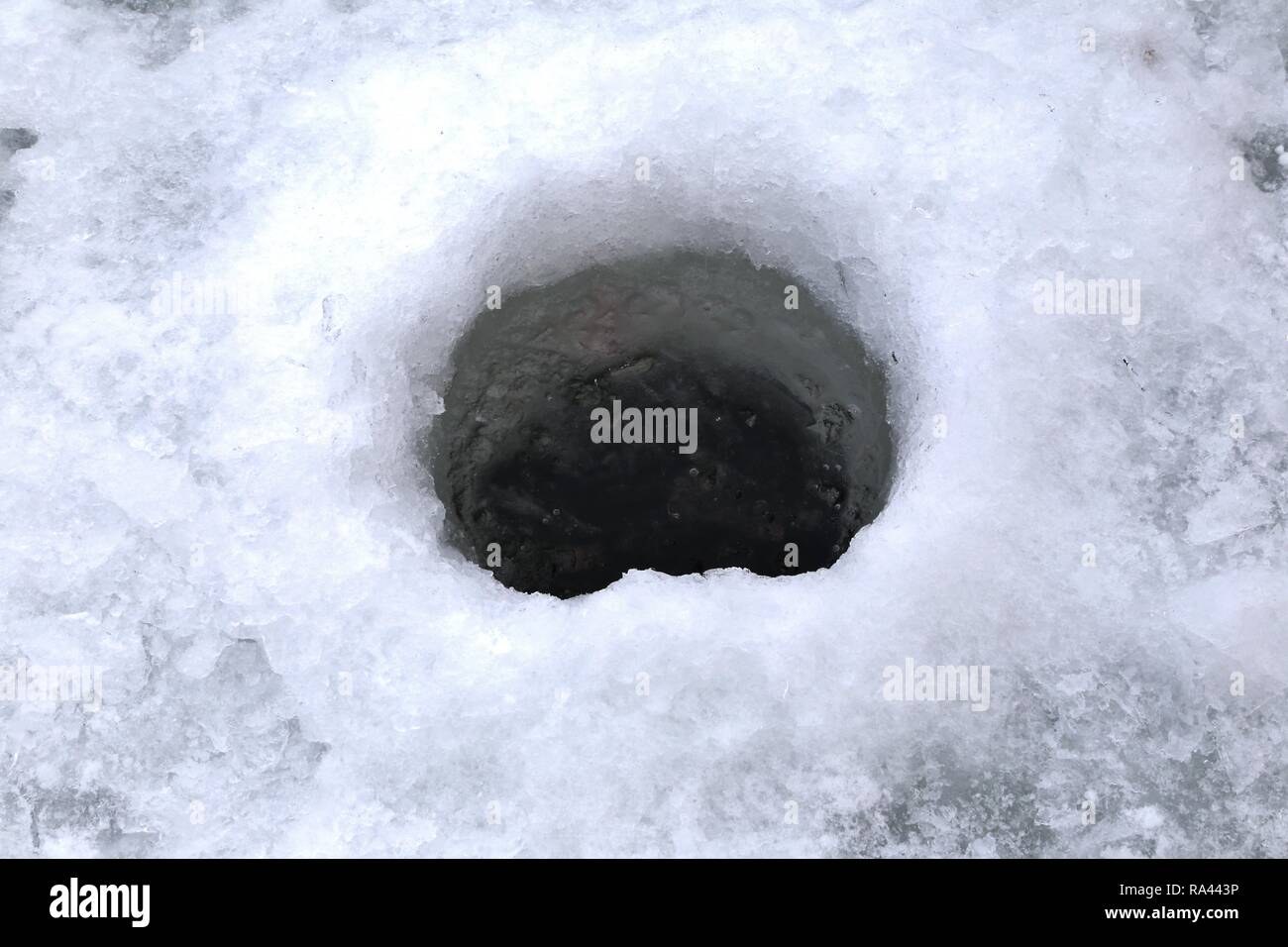 La pêche sur glace trou dans l'étang gelé Banque D'Images