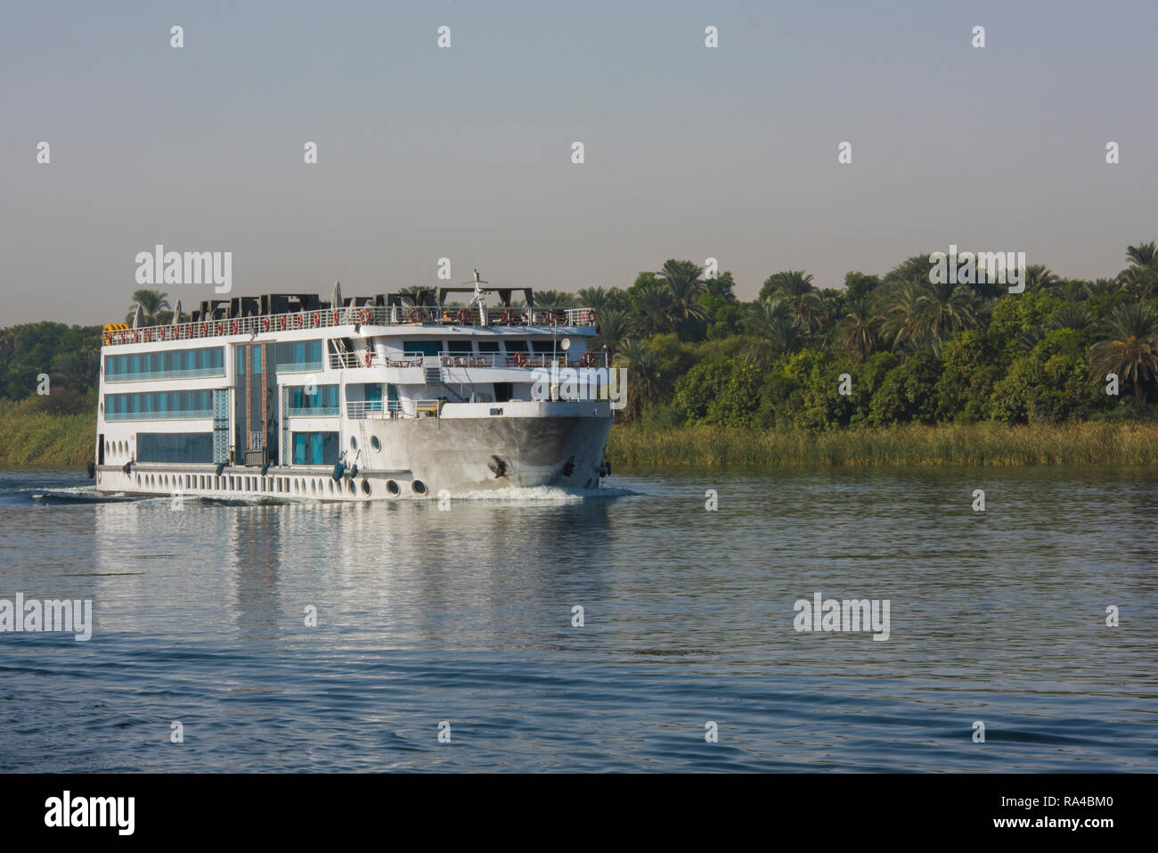 Grand luxe croisière égyptienne traditionnelle bateau naviguant sur le Nil avec réflexion Banque D'Images