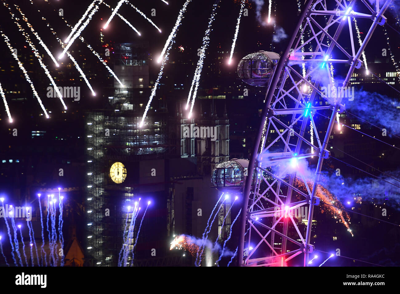 Feux d'artifice illuminent le ciel au-dessus de l'Oeil de Londres au centre de Londres pendant les fêtes de fin d'année. Banque D'Images