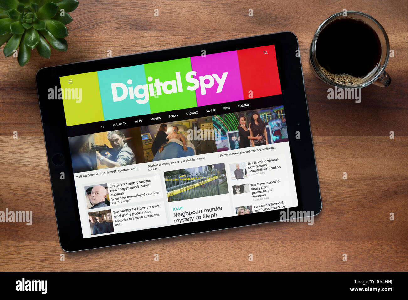 Le site web de Digital Spy est vu sur un iPad tablet, sur une table en bois avec une machine à expresso et d'une plante (usage éditorial uniquement). Banque D'Images