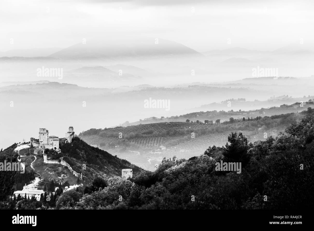 Belle vue sur le château de Rocca Maggior (Assise, Umbrfia, Italie) sur une mer de brume, avec des collines en arrière-plan Banque D'Images