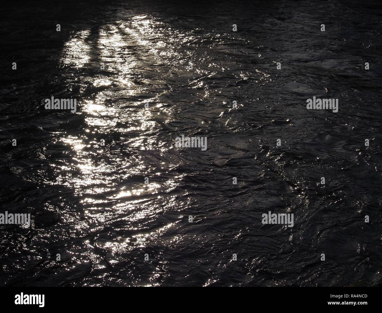 La lumière du soleil qui brille sur la surface de la rivière Derwent, Cockermouth, Cumbria, Angleterre, Royaume-Uni Banque D'Images