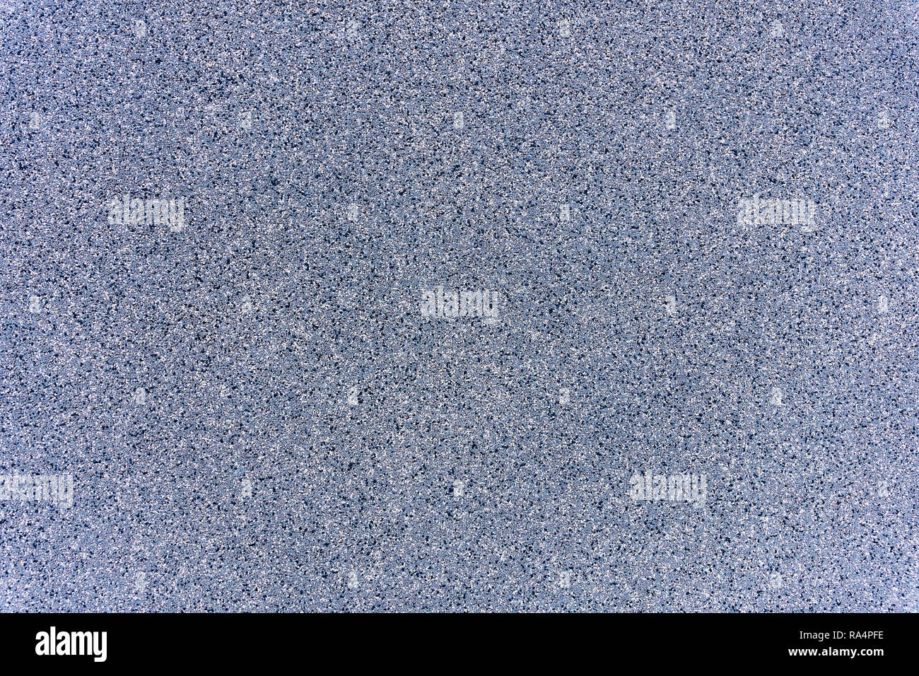 Un gros plan d'une surface de roche de granit gris traités plaque. Un fragment d'un mur de pierre de décoration. La texture du matériau granit gris lumineux. Banque D'Images