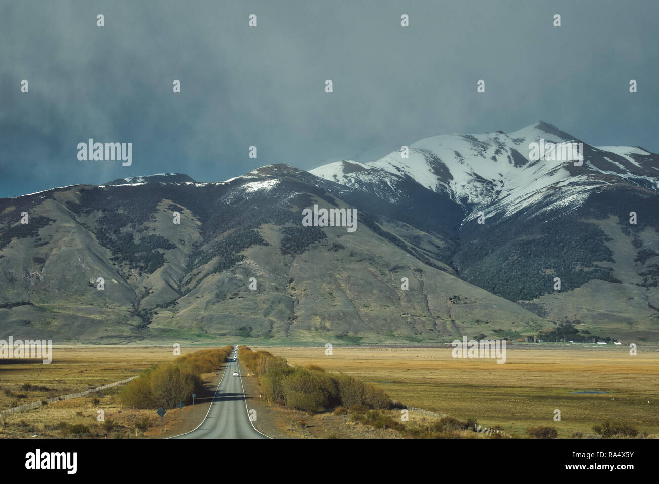 Le recul de la route goudronnée dans un paysage montagneux avec des sommets couverts de neige en Argentine, Amérique du Sud Banque D'Images