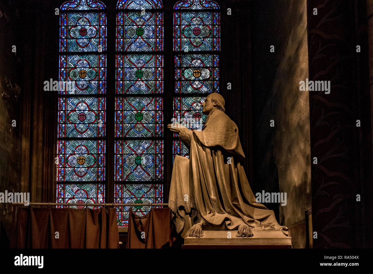 Une statue de Mgr Sibour, devant une magnifique et vert vitrail à la Cathédrale Notre-Dame de Paris , Banque D'Images