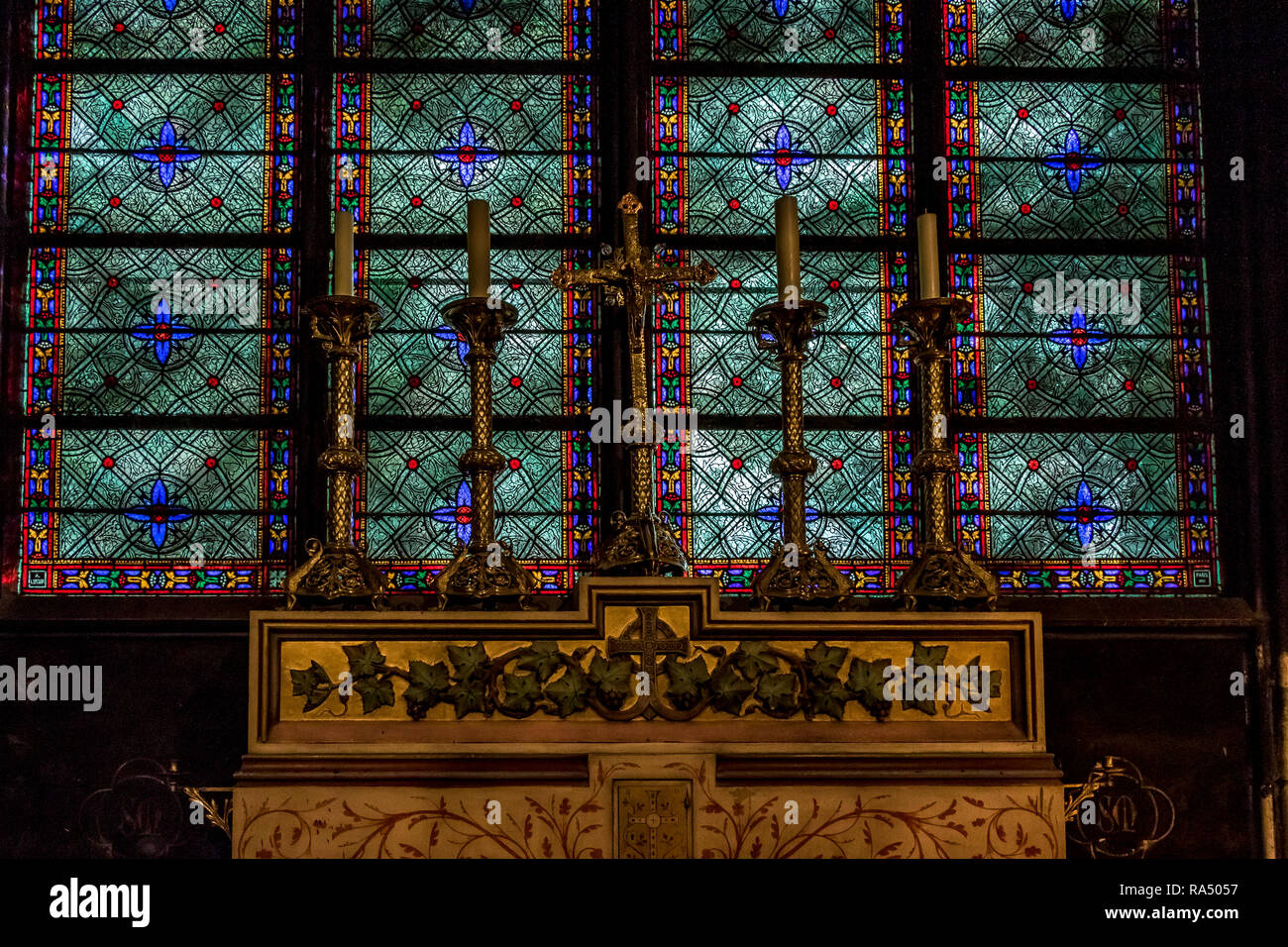 Changer les bougies dans Candler en laiton avec une superbe porte-vert et bleu vitrail derrière dans la Cathédrale Notre Dame, Paris Banque D'Images