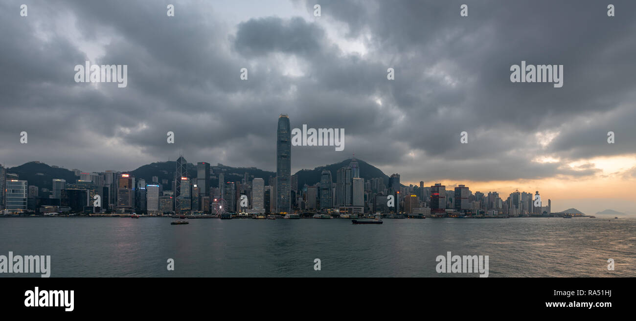 Le soleil se couche sur Kennedy Town et l'île verte dans l'ouest de l'île de Hong Kong, comme les lumières de la ville pour la nuit Banque D'Images