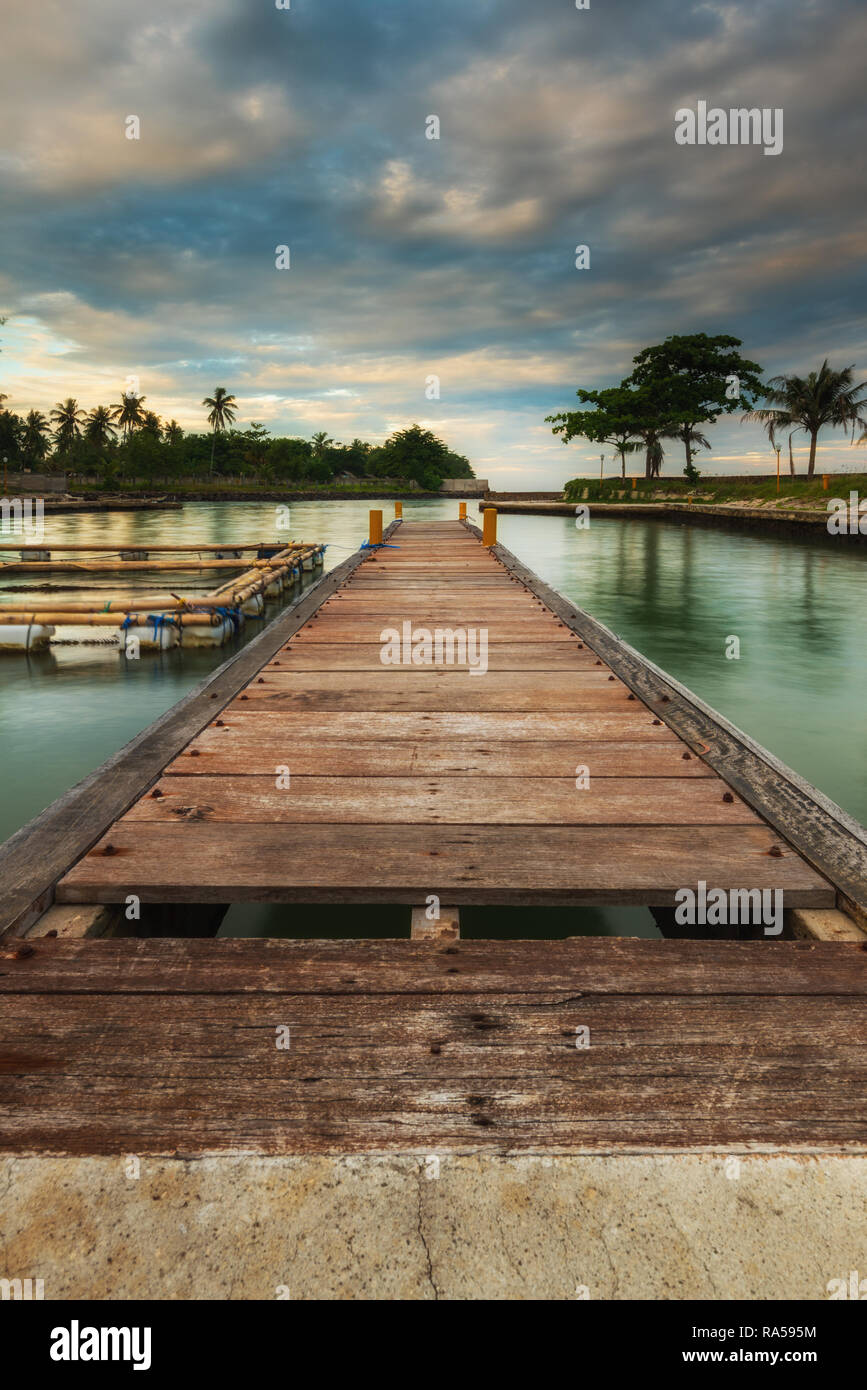 Jetée en bois en calme et ciel nuageux Banque D'Images