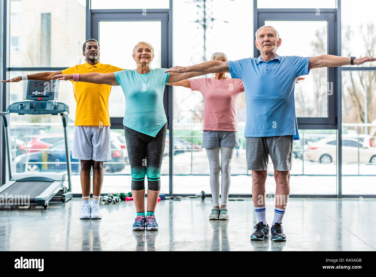 Les athlètes seniors multiethnique fait synchrone de l'exercice dans la salle de sport Banque D'Images