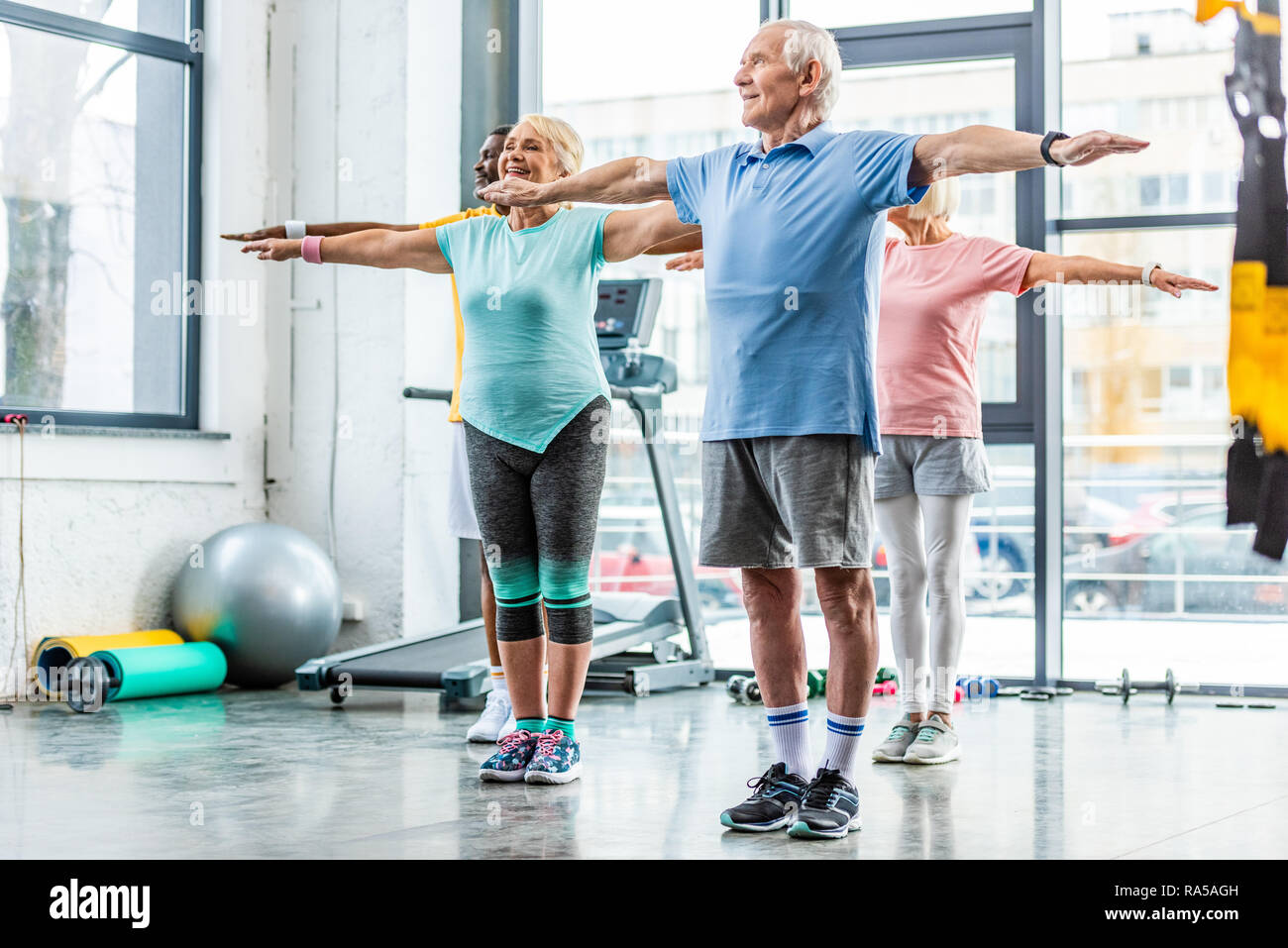 Les athlètes seniors multiethnique fait synchrone de l'exercice dans la salle de sport Banque D'Images