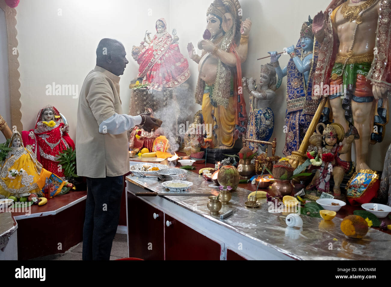 Un hindou pieux adorateur prie et médite en face des statues de divinités dans un temple en Jamaïque, Queens, New York. Banque D'Images