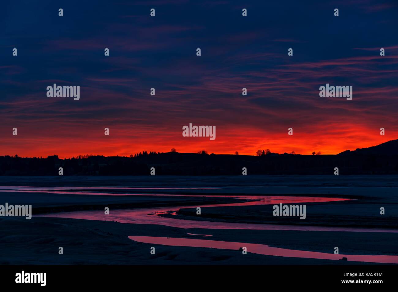 Heure bleue ciel rouge et rouge réflexion dans la rivière Lech, Forggensee, Füssen, Ostallgäu, Bavière, Allemagne Banque D'Images