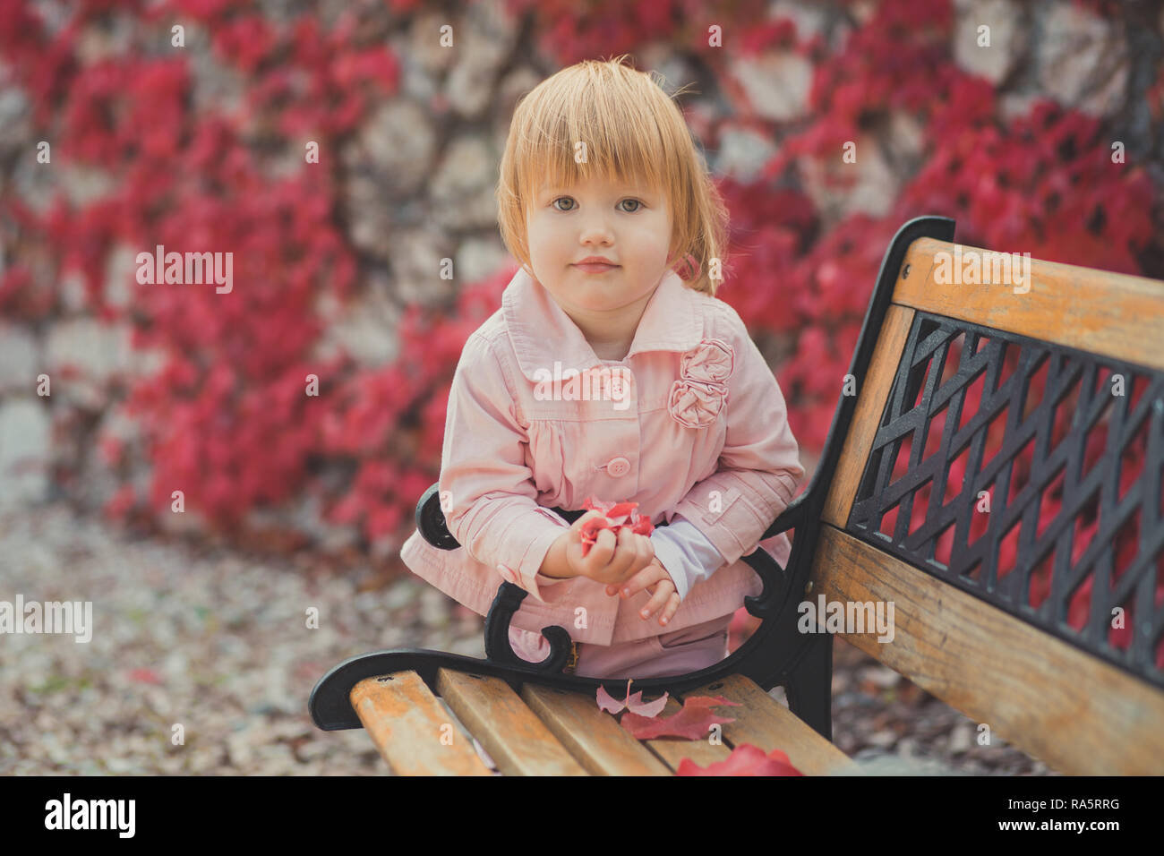 Bebe Fille Mignonne Avec Des Cheveux Blonds Et Pink Apple Joue Beneficiant Printemps Automne Vacances Temps Posant Dans Beau Jardin Plein De Fleurs Sur Le Banc Portant Des Pi Photo Stock