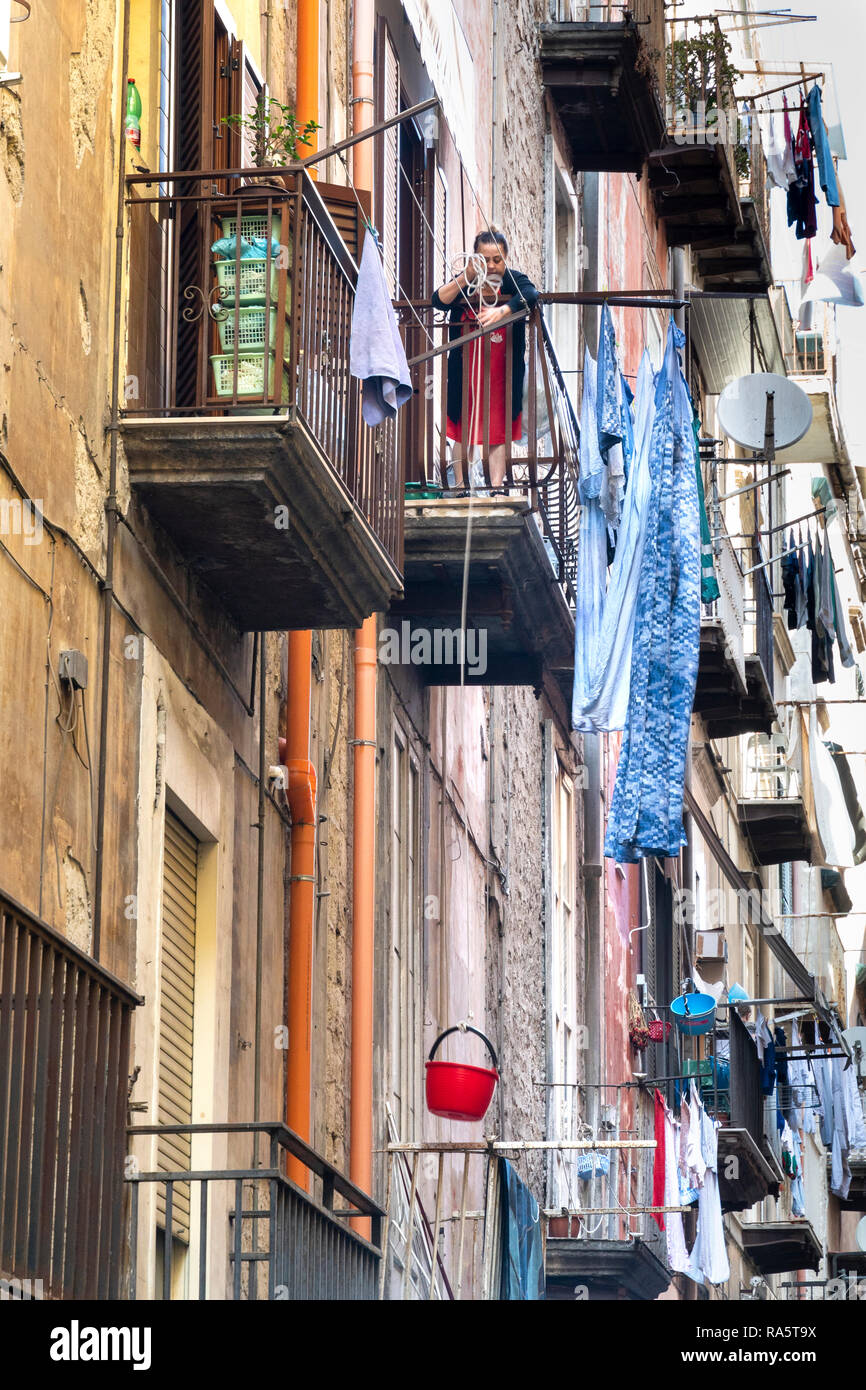 Une femme utilise un seau en plastique pour soulever votre jusqu'à son appartement de la rue un courant dans le centre historique, le centre historique de Nap Banque D'Images Une femme utilise un seau en plastique pour soulever votre jusqu'à son appartement de la rue un courant dans le centre historique, le centre historique de Nap Banque D'Images