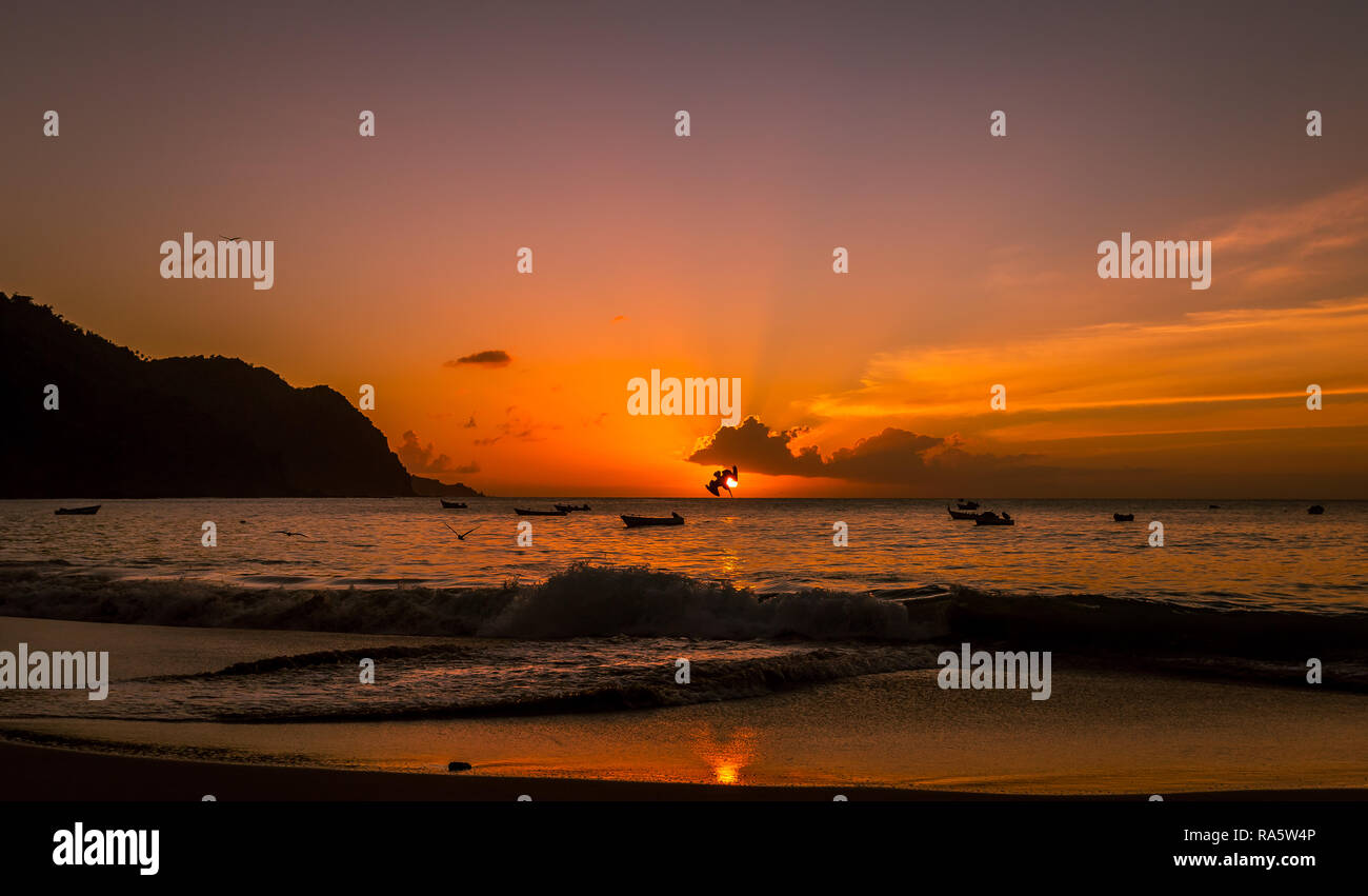 Tobago, Antilles, Caraïbes. Magnifique coucher de soleil sur l'océan, dans le village de pêcheurs de Castara avec les oiseaux de mer et les pélicans plongeant dans l'océan. Banque D'Images
