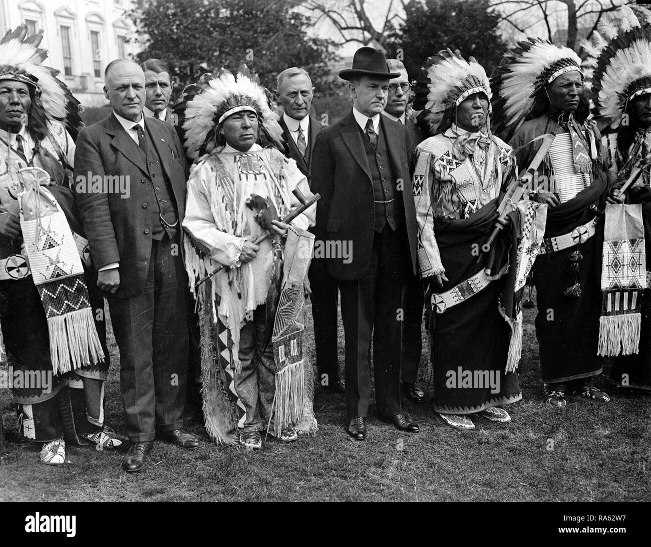 Le président Calvin Coolidge avec les Indiens en tête des robes et des vêtements traditionnels ca au début des années 1900. Banque D'Images