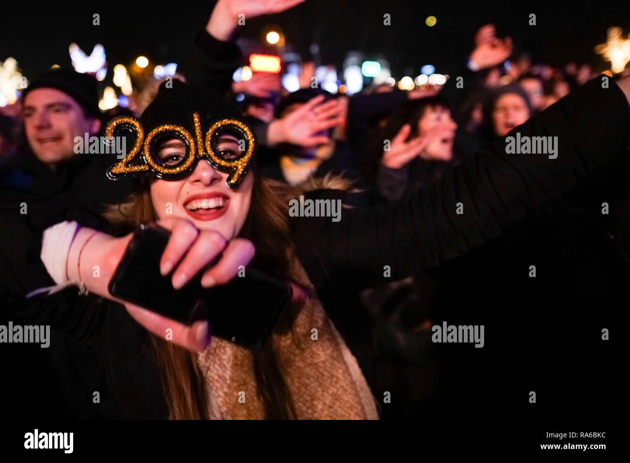 Une femme vu portant des lunettes de 2019 célébrant le Nouvel An à Vienne. Plusieurs étapes avec différents style de musique, du classique au rock, exécutaient dans Silvesterpfad, Vienne. Banque D'Images