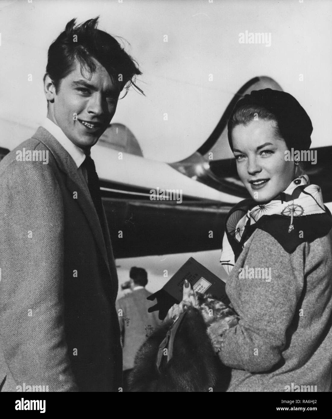 Mar. 03, 1959 - engagé ? Romy Schneider tenant son ''Reisepass" vu à l'aéroport d'Orly quand elle a pris l'avion pour la Suisse. Avec elle est le jeune acteur français Alain Delon. Il est dit que le couple pourrait bientôt annoncer leur engagement. (Crédit Image : © Keystone Press Agency/Keystone USA par ZUMAPRESS.com) Banque D'Images