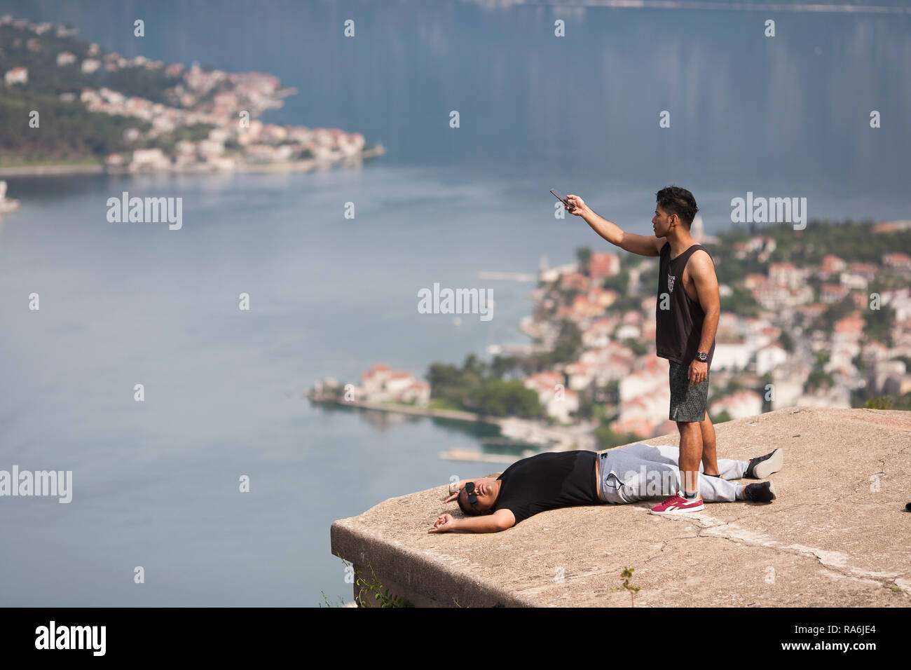 Les touristes prendre des autoportraits et photos de l'autre du mâchicoulis du château et forts au-dessus de Kotor, Monténégro Banque D'Images