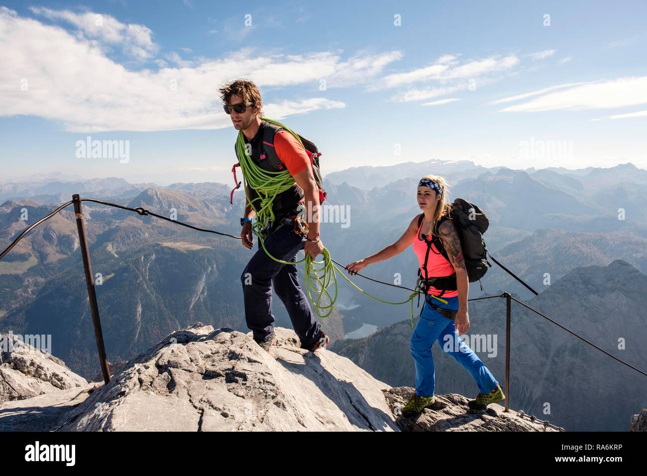 Guide de montagne de guider une jeune femme sur une courte corde par une via ferrata, Watzmann, Schönau am Königssee Banque D'Images