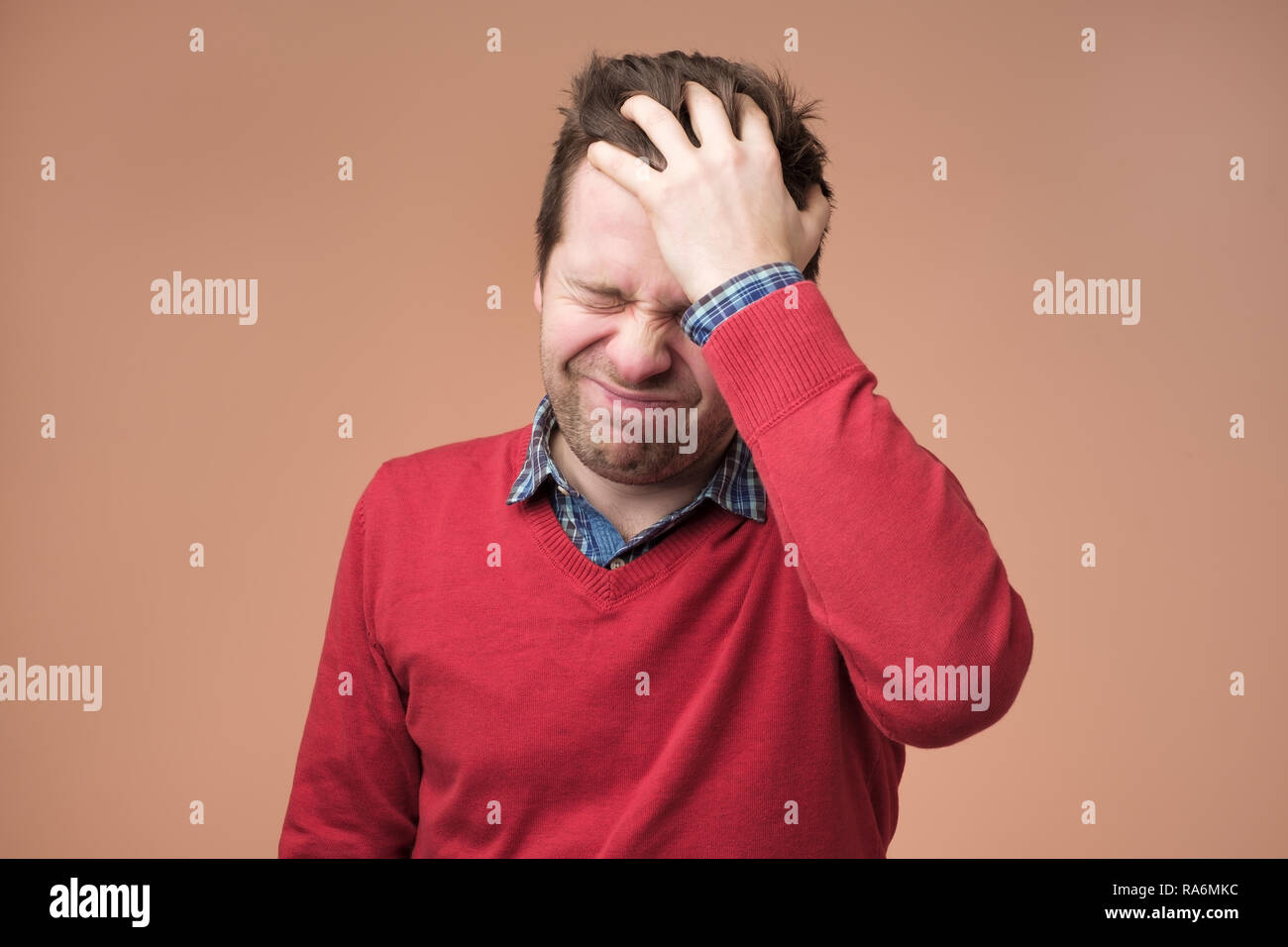 Maux de tête et migraines, l'homme avec la tête sur fond brun Banque D'Images