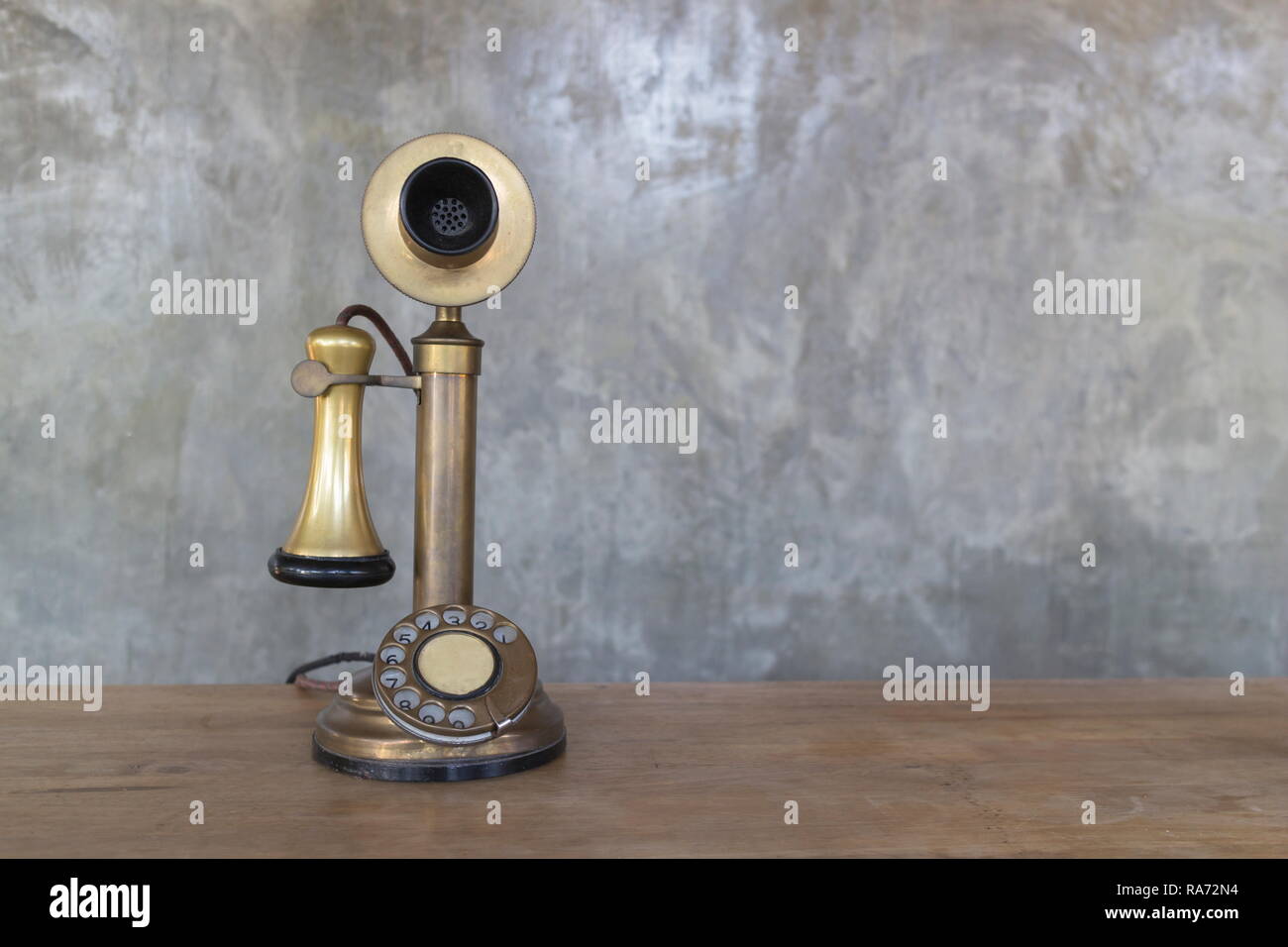 Téléphone Vintage sur table en bois avec mur de ciment, d'arrière-plan droit avec copie espace. Banque D'Images