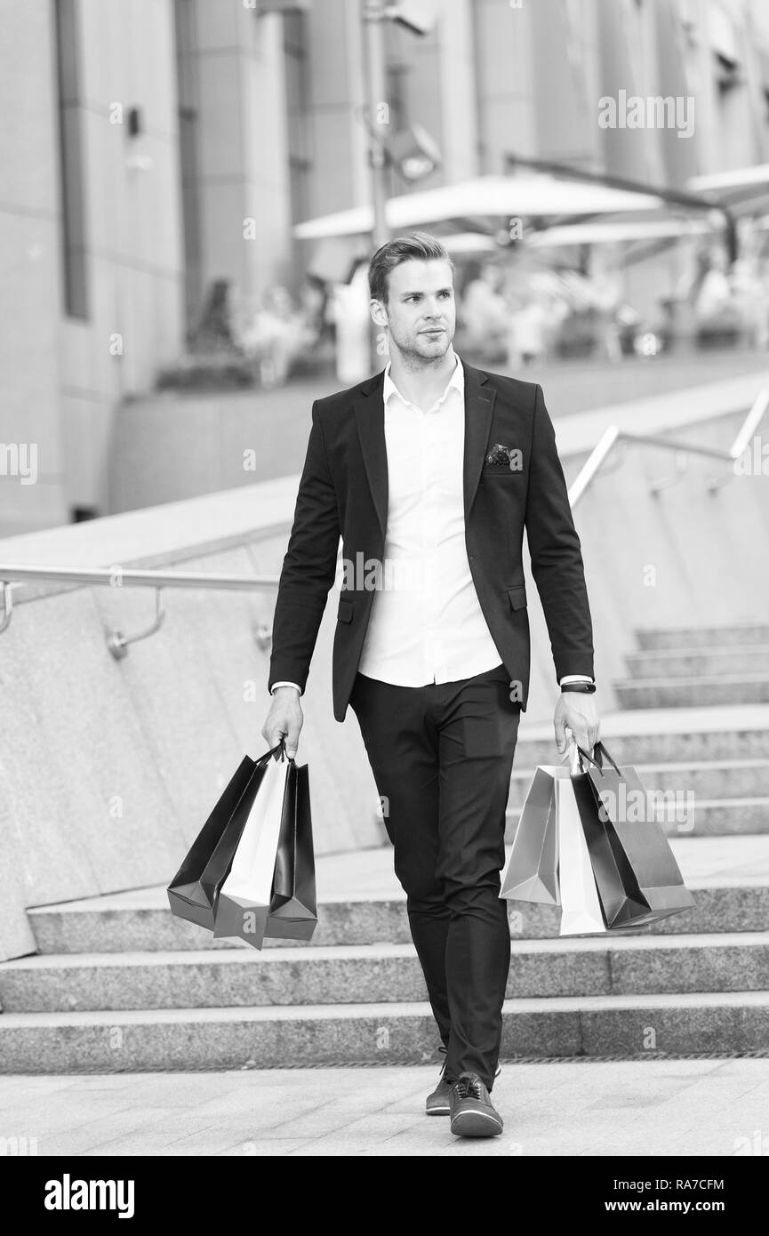 Guy transporter des sacs de magasinage bunch. Des affaires shopping sur le black  friday. Maintenez l'homme sacs sacs papier lot après shopping in mall. Le  vendredi noir vente concept. Homme costume formel