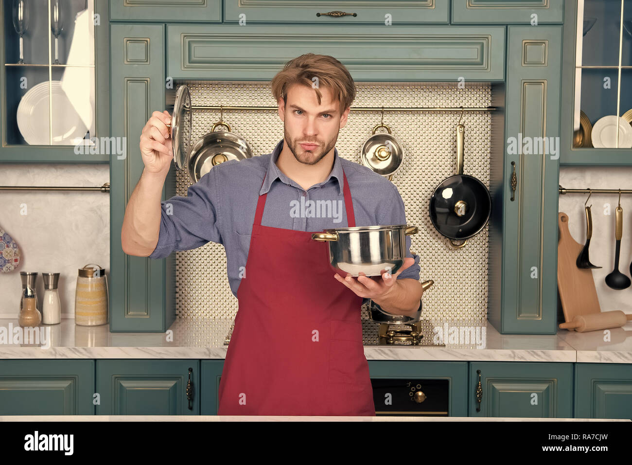 Maintenez l'homme Cook casserole et couvercle en cuisine. Batterie de  cuisine, ustensiles de cuisine, de l'outil. Avec marmite macho pour ragoût,  soupe plats. Cuisine traditionnelle, la cuisine, la préparation des  aliments. Plats,