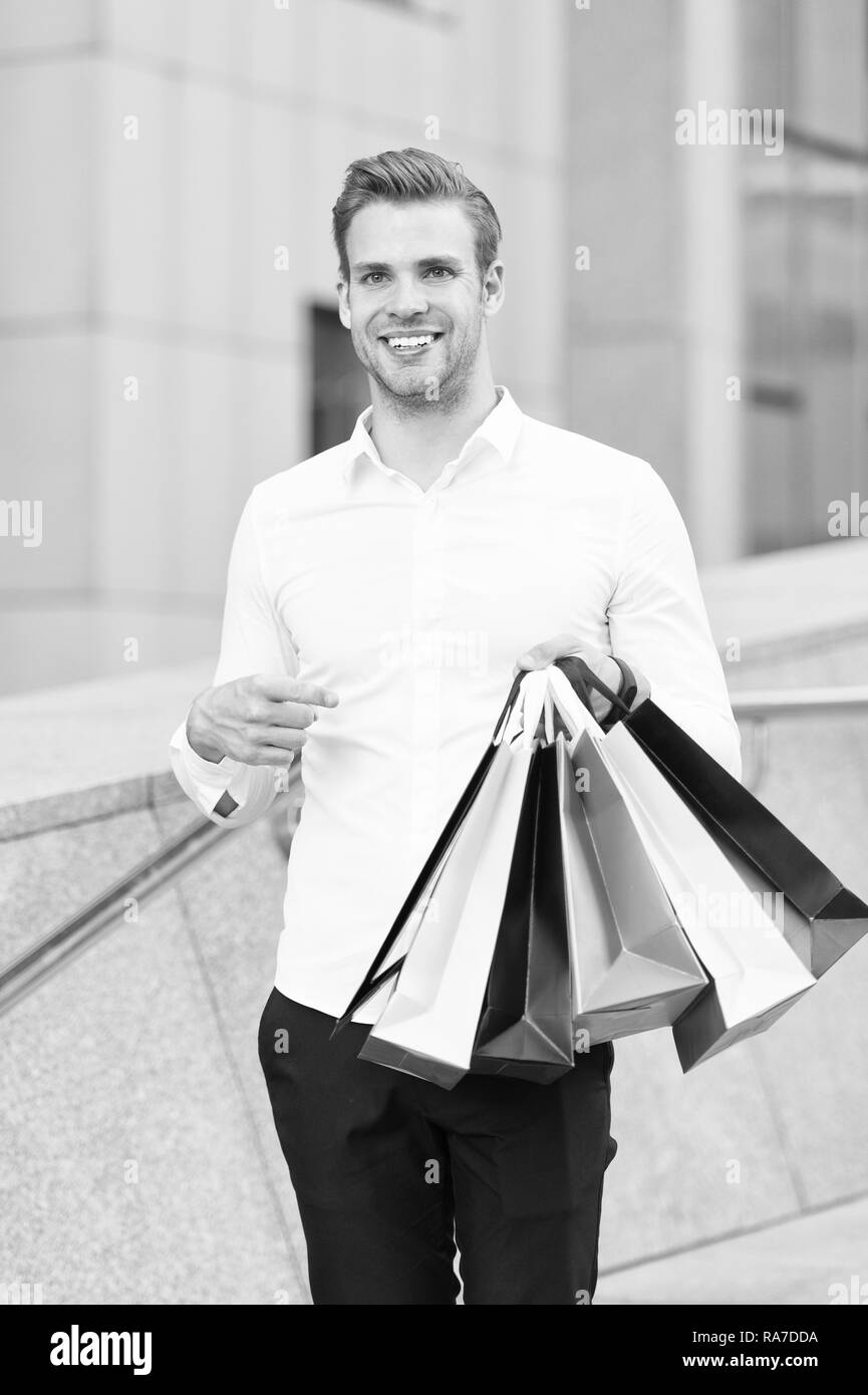 Homme Vêtements officiels portent des sacs de magasinage. Guy heureux faire bande sacs. Des affaires. C'est sur le noir vendredi. Maintenez l'homme sacs sacs papier lot après shopping in mall. Le vendredi noir vente concept. Banque D'Images