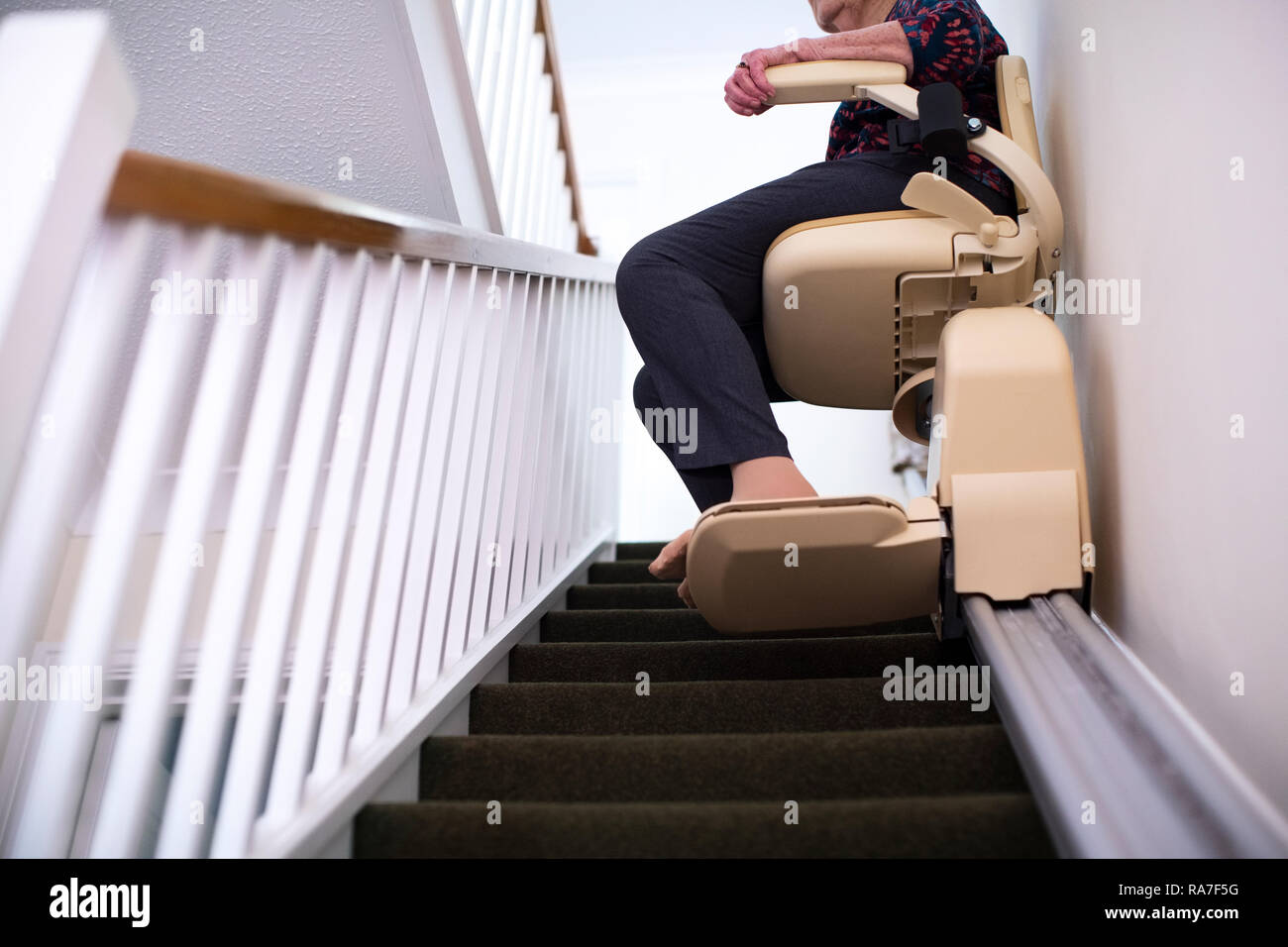 Détail de Senior Woman Sitting on monte-escalier à la maison pour aider à la mobilité Banque D'Images