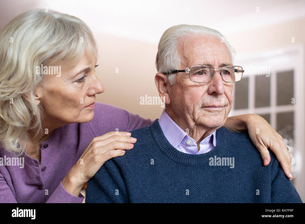 Confused Senior homme souffrant de dépression et de la démence d'être réconforté par femme Banque D'Images