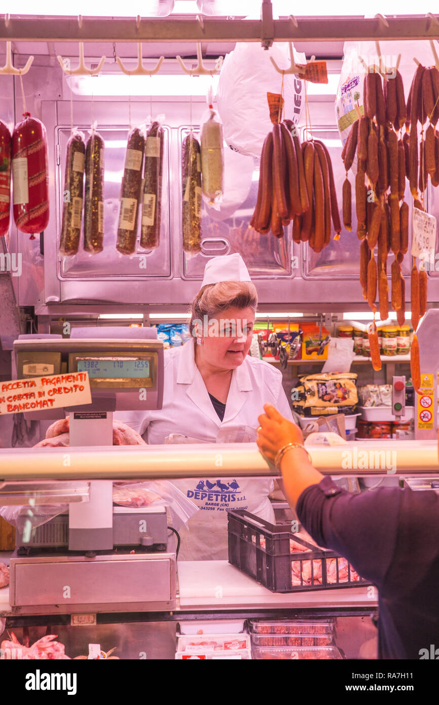 Un vendeur à l'intérieur de la boucherie du marché central de Turin, Italie Banque D'Images